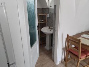a bathroom with a sink and a table and a chair at Casetta nel Centro Storico in Martina Franca