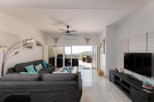 a living room with a couch and a flat screen tv at Bayridge 48 ~ Penthouse in Ballito