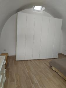 a bedroom with white cabinets and a bed at Casetta nel Centro Storico in Martina Franca