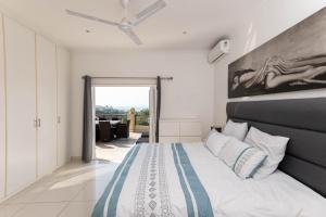 a bedroom with a bed and a ceiling fan at Bayridge 48 ~ Penthouse in Ballito