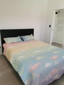 a bedroom with a large bed with a colorful blanket at Paradise Retreat in Tauranga