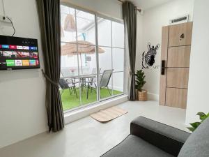 ein Wohnzimmer mit Sofa und Tisch in der Unterkunft Relax Private terrace&cozy BR,near Grand palace in Bangkok