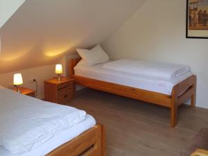 two twin beds in a room with two lamps at Ferienwohnung Wolf in Nietwerder