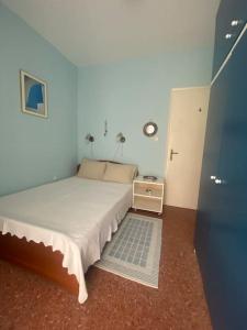 a small bedroom with a bed and a night stand at Anastasia's Seaview apartment in Hanioti