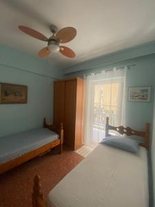 a bedroom with two beds and a ceiling fan at Anastasia's Seaview apartment in Hanioti