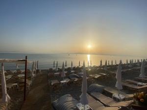 a group of umbrellas and chairs on a beach at Anastasia's Seaview apartment in Hanioti