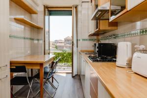 a kitchen with a wooden table and a counter top at ShortMi Balilla in Milan