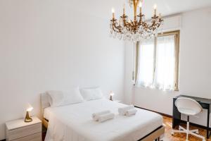 a bedroom with a white bed and a chandelier at ShortMi Balilla in Milan