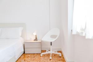 a bedroom with a white chair next to a bed at ShortMi Balilla in Milan