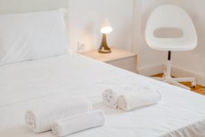 a white bed with three rolled towels on it at ShortMi Balilla in Milan