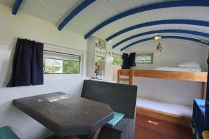 Zimmer mit einem Tisch und einem Etagenbett in der Unterkunft Tiny house Roodborstje in Oudesluis