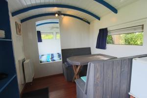 a kitchen and dining area of a tiny house at Tiny house Roodborstje in Oudesluis