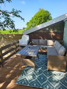 patio con divano e tavolo sul ponte di Jelsum aan de Ee a Jelsum