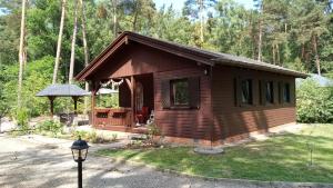a log cabin with a porch and a gazebo at Ferienhaus Bea in Buchholz Aller