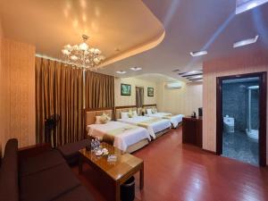 um quarto de hotel com duas camas e um sofá em Khách sạn INCO 515.9 em Phủ Lý