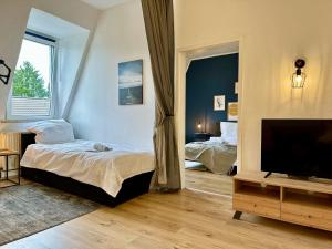 um quarto com 2 camas e uma televisão de ecrã plano em Stylish im Altbau, Netflix, Sonos, nahe 3M und Vorwerk em Wuppertal