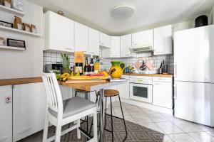 kuchnia z białymi szafkami, stołem i krzesłami w obiekcie * Loft 3 pièces/Calme, tout équipé @ Centre Ville w Strasburgu +25 zdjęć