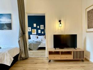 uma sala de estar com televisão e um quarto em Stylish im Altbau, Netflix, Sonos, nahe 3M und Vorwerk em Wuppertal