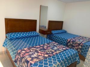 two beds in a room with blue and pink beds at Ashour Tower Ramy Abdulla For Families only in Marsa Matruh