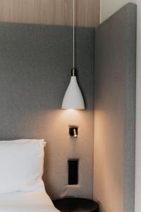 um quarto com uma cama e uma luz pendurada na parede em Somnus Suites Parga em Parga