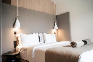 um quarto de hotel com duas camas com almofadas brancas em Somnus Suites Parga em Parga