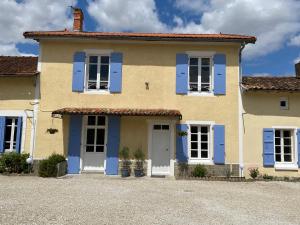 a yellow and blue house with blue shutters at L'ancien Cafe - Suites and Gites 