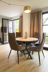 una sala da pranzo con tavolo e sedie in legno di Neues Friesenhaus Oogenstern Ferienhaus Usedom -stufenlos im Erdgeschoß- ruhige Lage a Zirchow