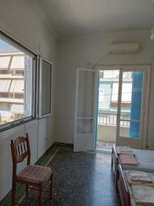 a bedroom with a chair and a bed and a window at Το ησυχο σπιτι in Athens