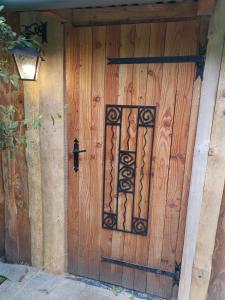 een houten deur met een ijzeren hek erop bij Cabane en bois sur l'étang in Landisacq