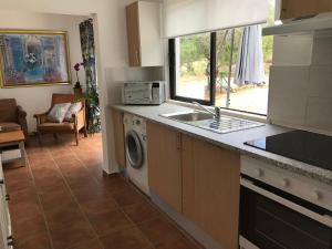 cocina con fregadero y lavadora en Casa tranquil en Santa Bárbara de Nexe