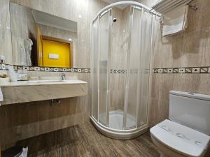 a bathroom with a shower and a toilet and a sink at Hotel Rural Casa Migio in Urbiés +80 photos