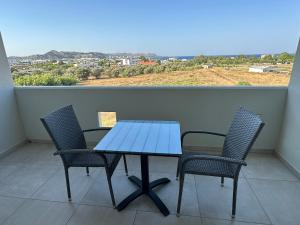a table and chairs on a balcony with a view at Faliraki Star in Faliraki