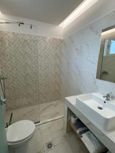 a bathroom with a sink and a toilet and a shower at Faliraki Star in Faliraki +33 photos