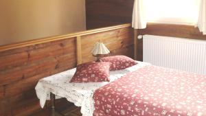 1 dormitorio con 1 cama con mesa y lámpara en Country House Trnac, en Tuhelj