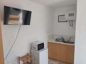 a kitchen with a tv hanging on the wall at Habitacion puerto 1 o 2 personas in San José