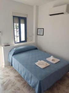 a bedroom with a blue bed with two towels on it at Habitacion 1 o 2 personas in San José