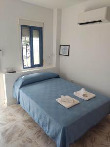 a bedroom with a blue bed with two towels on it at Habitacion puerto 1 o 2 personas in San José