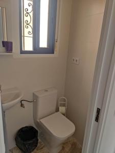 a bathroom with a toilet and a sink and a window at Habitacion puerto 1 o 2 personas in San José
