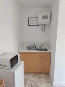 a kitchen with a microwave and a sink at Habitacion puerto 1 o 2 personas in San José +8 photos