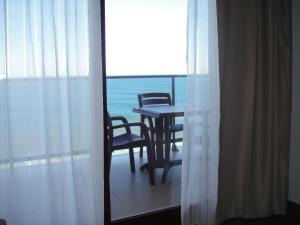 a table and chairs in a room with a view of the ocean at Aparthotel El Faro in Cullera