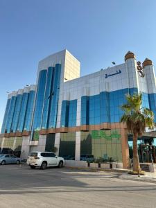 فندق لافيرا الرويبح Lavera Hotel في الرياض: مبنى كبير فيه سيارات تقف امامه