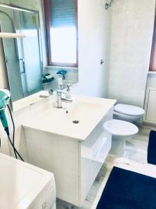 Baño blanco con lavabo y aseo en Residence Tigli Campomarino, en Campomarino