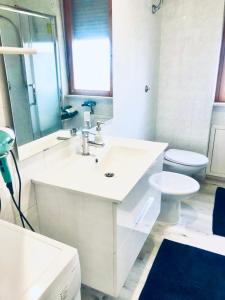 a white bathroom with a sink and a toilet at Residenza Tigli Campomarino Lido in Campomarino +10 photos