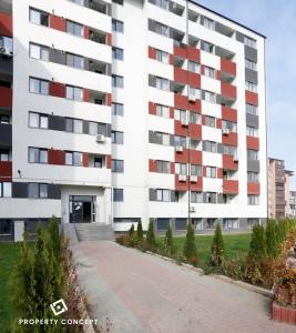 un gran edificio blanco con ventanas rojas y entrada en Avangarde Concept Studio, en Roşu