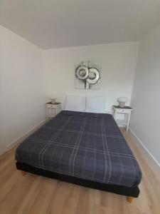 a bedroom with a bed with a blue plaid blanket at appartement quai de la Fontaine in Nîmes