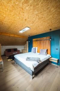 - une chambre avec un grand lit et un plafond en bois dans l'établissement B&B La Forge de Diogne, à Crans-Montana