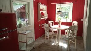 a red dining room with a white table and chairs at Ferienhaus Bea in Buchholz Aller