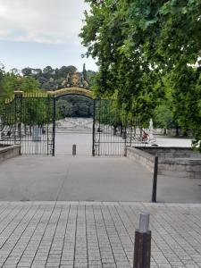 a large gate in a park with a fountain at appartement quai de la Fontaine in Nîmes
