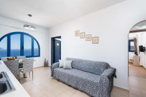 a living room with a couch and a table at Caldera Heights Apartment in Akrotiri