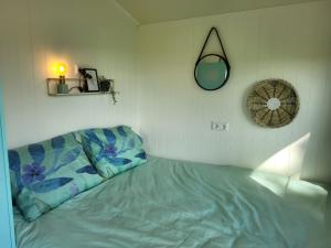 una camera da letto con un letto e uno specchio a parete di Jelsum aan de Ee a Jelsum